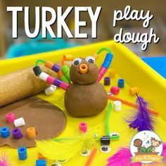 there is a turkey play dough with crayons and beads in it on the tray