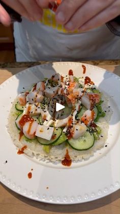 a plate with food on it sitting on a table next to a person's hand