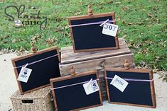 four chalkboards are tied to wooden boxes on the ground