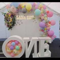 balloons and confetti decorate the entrance to a one - sided tented event