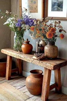 some vases and flowers on a wooden table