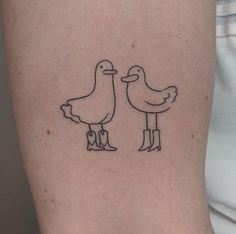 two birds standing next to each other on the back of a woman's arm