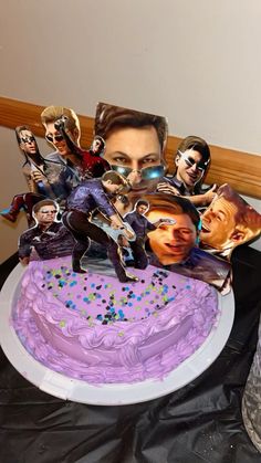 a purple cake with pictures of people on it and sprinkles around the edges