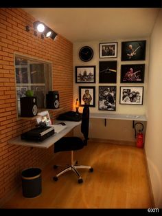 a room with a desk, speakers and pictures on the wall