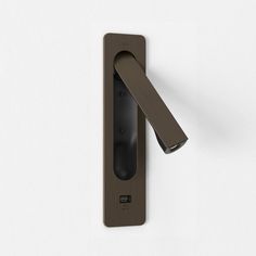 an open door handle on a white wall with a dark brown finish and black accents