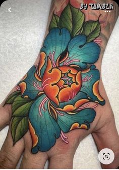 a person's hand with a flower tattoo on it