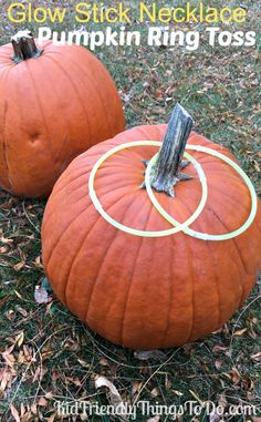 two pumpkins sitting in the grass with circles drawn on them and one has a stick sticking out of it