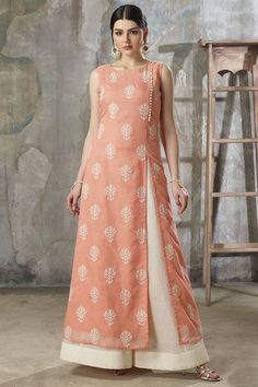 Wear a tasteful appeal dressed in this ecstatic peach designer suit featuring side-front seam enriched with contrasting ivory fabric buttons followed by a slit while the entire kurta shines in ivory thread embroidered motifs in a gorgeous look! This suit is accompanied by contrasting ivory shimmer cotton palazzo pants & dupatta. Palazzo Pants With Kurti Style, Palazzo Kurti Designs, Jaipur Kurti, Designer Dresses Couture, Party Wear Kurtis, Embroidered Motifs