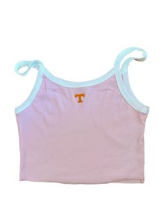 a pink and white tank top with the letter t on it's chest, in front of a white background