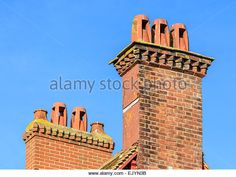 an old brick chimney on top of a building with blue sky in the background