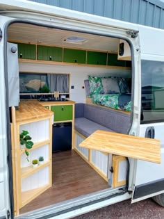 the interior of a camper van with its door open to reveal a kitchen and living area