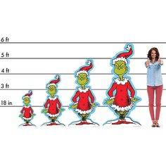 a woman standing in front of a line of dr seuss's christmas characters