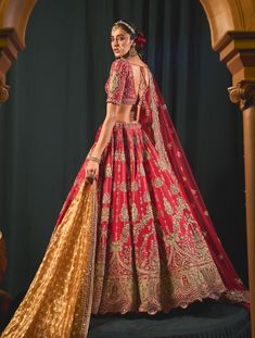 Step into refined elegance with this captivating red lehenga set, a breathtaking celebration of artistry. Crafted from luxurious raw silk, the lehenga showcases intricate zari work, resham dori, and sequins, highlighting its opulent design. The skirt features vertical motifs and an extensive border, creating stunning flair with every movement. The extensively embroidered blouse boasts floral mesh detailing, perfectly complementing the ensemble. A rich red net dupatta adds a finishing touch, adorned with scalloping in the corners and shiny sequins, elevating this piece to an exquisite statement of style and sophistication. Luxury Katan Silk Lehenga With Zari Weaving, Red Lehenga, Zari Work, Net Dupatta, Red Fabric, Raw Silk, Embroidered Blouse, Innovation Design, Lehenga