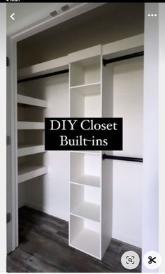 an open closet with white shelves and black handles on the doors, in front of a wooden floor