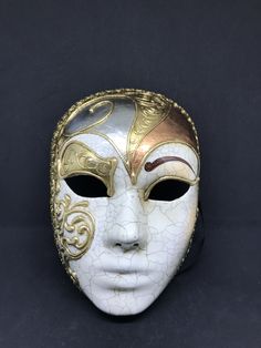 "Size: one size Traditional and original papier-mache Venetian mask, handmade and decorated with three leaf,gold,silver and bronze, cracked technique, stucco and acrylics. This traditional Venetian mask shape is called \"Volto mask\" and is a full face mask. All our masks are handmade papier-machè masks, made in Venice. Our decorators use techniques typical of the Venetian tradition such as stucco, acrylics, gold and silver-leaf, macramè, passementerie, pearls and crequelè to give you a wide ran Artistic White Masks For Festivals, White Venetian Masks For Festivals, White Venetian Masks And Prosthetics For Festivals, Volto Mask, Harlequin Mask, Paper Mache Mask, Venice Mask, Mask Shapes, Costume Masks