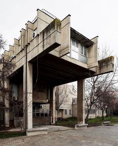 an apartment building with concrete pillars and balconies on the top floor is shown