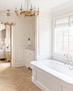 a bathroom with a tub and chandelier in it