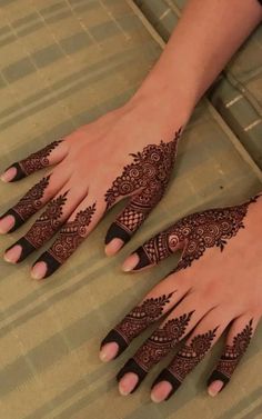 two hands with henna tattoos on them