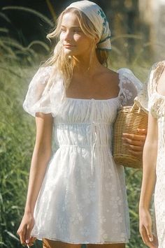 two women in white dresses are walking together