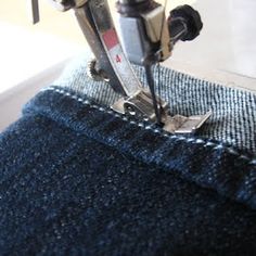 the sewing machine is working on some blue jeans and it looks like they have been sewn