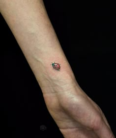 a ladybug tattoo on the left wrist