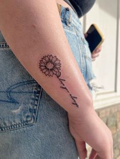 a woman's arm with a flower on it and the word love written in cursive writing