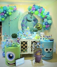 a birthday party with monsters and balloons on the wall, cake table and desserts