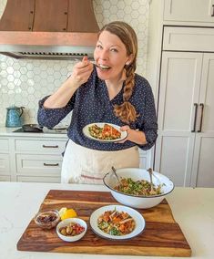 a woman in an apron holding a plate of food