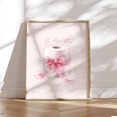 a pink toilet paper roll with a bow on it in front of a white wall