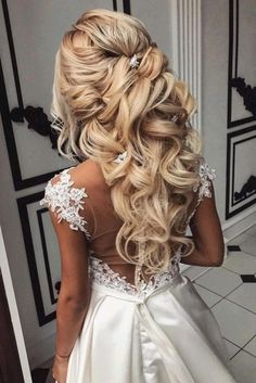 the back of a woman's wedding dress with long blonde hair