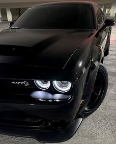 the front end of a black car in a parking garage