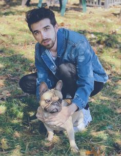 a man kneeling down holding a small dog