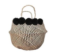 a black and white basket with pom poms