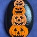 three carved pumpkins sitting on top of each other in front of a blue background