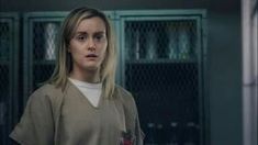 a woman in scrubs standing next to lockers