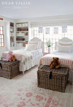 two twin beds in a bedroom with baskets on the floor and teddy bears sitting on them