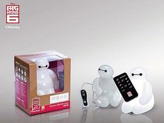 two white plastic figures sitting next to each other in front of a box and remote control