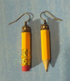 two yellow pencils are hanging from hooks