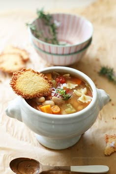 a bowl of soup with crackers on the side