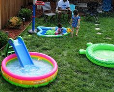 an inflatable pool with two children playing in it and another child standing next to it