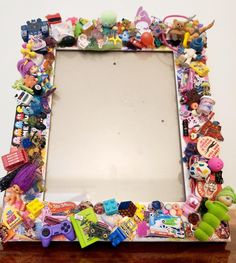 a wooden table topped with a mirror covered in toys