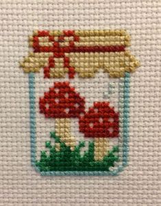 a cross stitch pattern with mushrooms in a jar