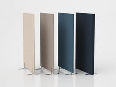 four different colored partitions are lined up against each other on a white surface,