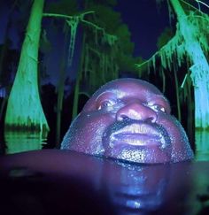 a man with his face covered in water at night