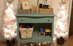 a small blue table with christmas lights on it and some decorations in front of it