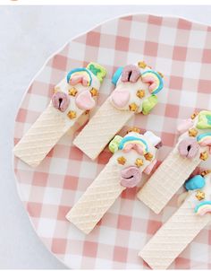 three ice cream treats are arranged on a pink and white checkerboard plate,