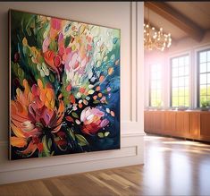 a large painting is hanging on the wall in an empty room with wooden floors and chandelier