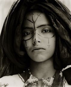 an image of a woman with makeup on her face and arrows painted on her forehead