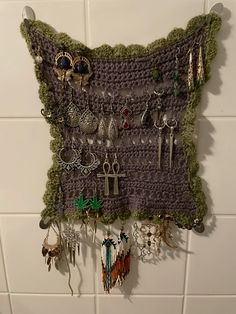 a crocheted wall hanging with earrings on it