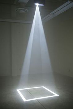 a white light shines brightly on the floor in an empty room with no people